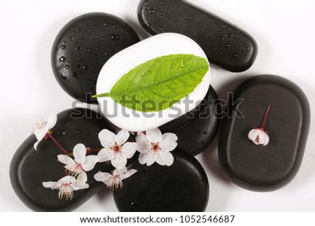 black stones for massage lie on a white table