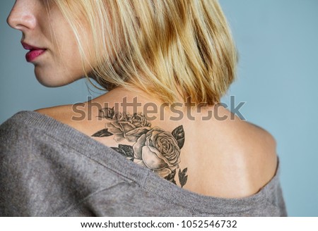 Back tattoo of a woman Royalty-Free Stock Photo #1052546732