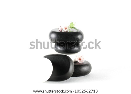 black stones for massage lie on a white table