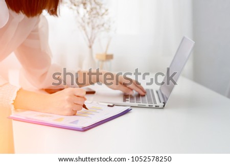 Business woman holding pen pointing on summary report chart