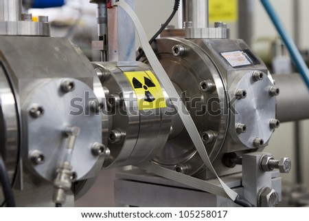 View of important electronic and mechanical parts of ION Accelerator, with high radiation sign, CNC machined parts Royalty-Free Stock Photo #105258017