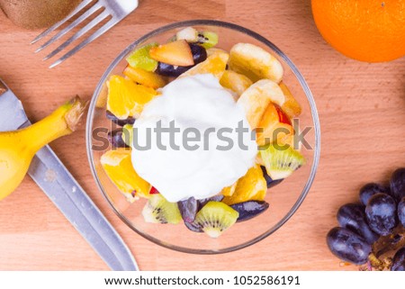 Delicious fruit salad with Greek yoghurt on a wooden table - fruit diet