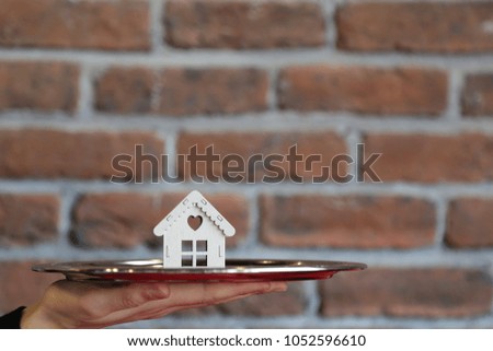 Wooden miniature house design on  serving tray on vintage  background, real estate and property business concept