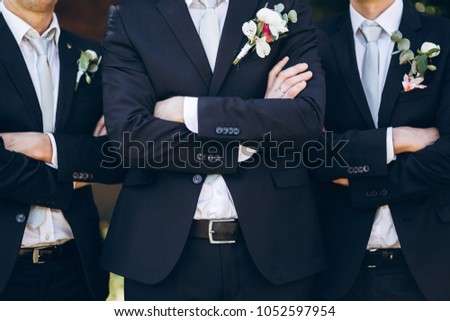 stylish groom in suit posing with groomsmen in garden on wedding day. luxury men in  rich outfits standing together. friendship Royalty-Free Stock Photo #1052597954