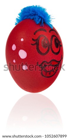 Easter egg, painted in smiling cartoon face of girl. Decorated egg with funny colorful hairstyle and multi-colored patterns. Easter decoration on a white background with a light reflection.