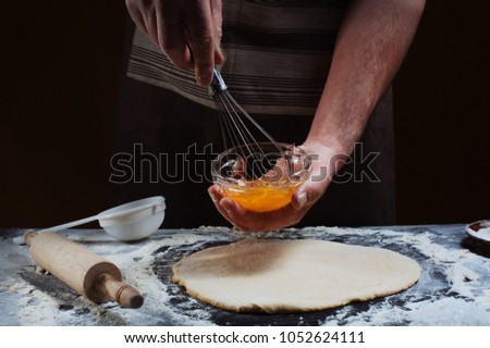 
Cooking pizza with mixer by chef hands in glass bowl and ingredients loft background. Chef mixing eggs yolk