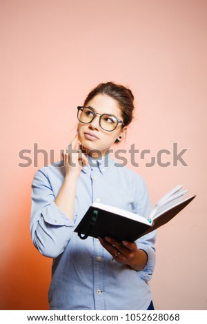 Girl thinking woth notepad in hands and wearing eyeglasses