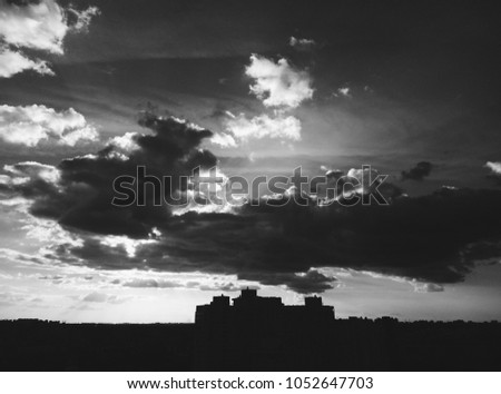 Black and white city. Beautiful clouds over buildings. Spring. Minimalism.