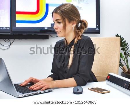 Businesswoman working on her laptop on a conference desk in a meeting room at the office