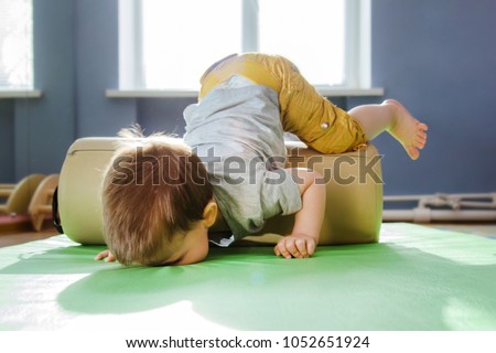 the child fell face down on the mat during a session with a roller Royalty-Free Stock Photo #1052651924