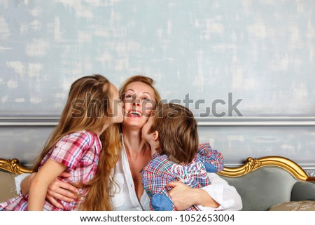 Small cute kids kiss their Mom. Concept: Mother's Day, happy family