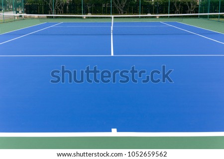 Outdoors blue tennis court and net on hard floor