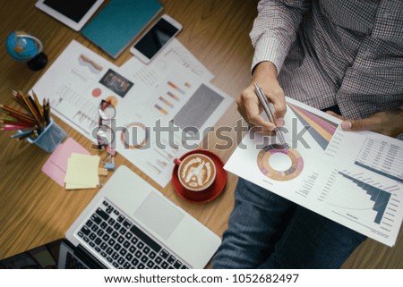 Businessman hand with Financial charts and laptop on the table. report papers and Office table, Corporate Business Planning with business chart Teamwork Concept. Top view.