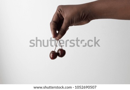 Beautiful African American female hand holds cherry cherries gesture. Isolated on white background