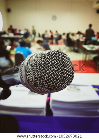 Microphone with abstract blurred photo of conference hall or seminar room with attendee background