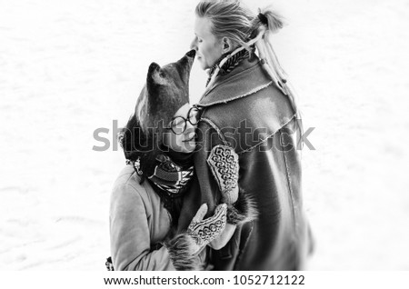 a hippy couple in love - a guy with dreadlocks and a girl with glasses and ethnic clothes and a hat hugging, black and white photo