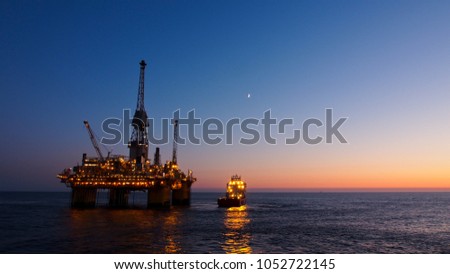 Silhouette of a floating production platform in North Sea region, Norway with sunset as background. Royalty-Free Stock Photo #1052722145