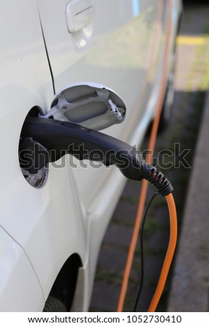 Electric Car Power Supply charging on charge station electro mobility environment friendly Royalty-Free Stock Photo #1052730410