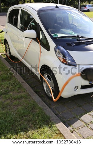 Electric Car Power Supply charging on charge station electro mobility environment friendly Royalty-Free Stock Photo #1052730413