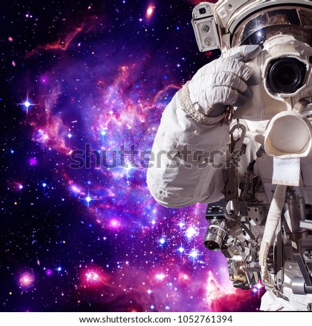 Astronaut with a camera makes a photo. The elements of this image furnished by NASA.
