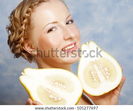 Girl holds in really big citrus fruit - pamelo, over sky background