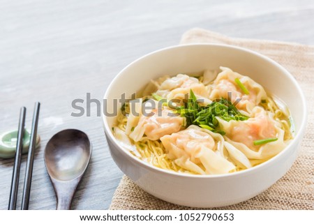 Shrimp wonton with braised pork in soup on wooden table - Asian food style, Select focus image Royalty-Free Stock Photo #1052790653