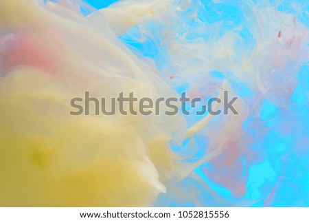 Abstract background of dissolving fluids on a sky blue background.