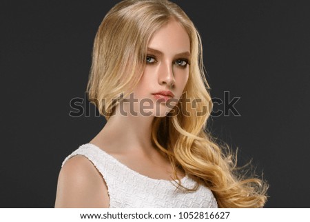 Woman with Curly long hair blonde young model. Beauty girl with perfect hairstyle. Studio shot.
