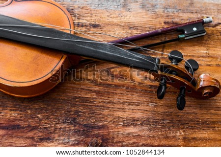 Violin and bow on a brown wooden table background. torn chord