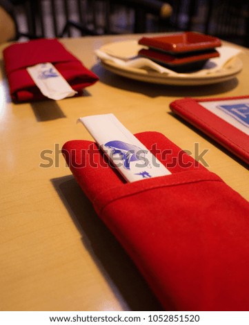 Chopsticks neatly folded in red napkins.  