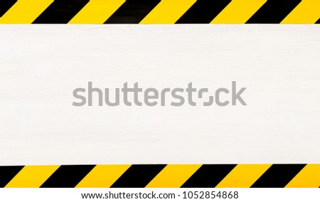 Under construction concept background. Warning tape frame on white wooden surface background with copy space. Royalty-Free Stock Photo #1052854868