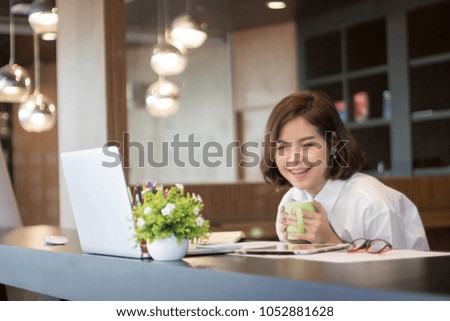 Beautiful happy young curly woman using laptop in the office.