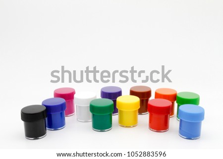 Set of color gouache jars and acrylic paints on white background.
