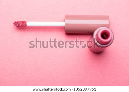 Brush for make-up lips and the bottle of liquid lipstick close-up on a pink background with copyspace Royalty-Free Stock Photo #1052897951