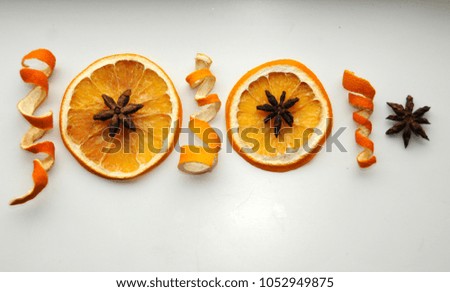 Orange slices, curly peels and star anise decorative composition on white background