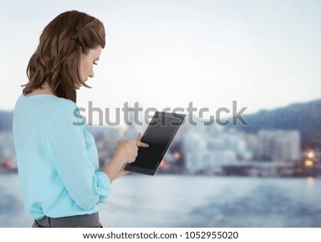 Digital composite of Businesswoman holding tablet with distant city background