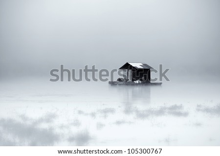 Wooden Hut on the mystical lake wrapped in fog.Can be used for background on computers, book covers or wallpaper walls.Black and White photo