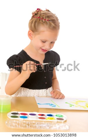 A little girl paints with paint and brush. The concept of children's creativity, happy childhood. Isolated on white background.