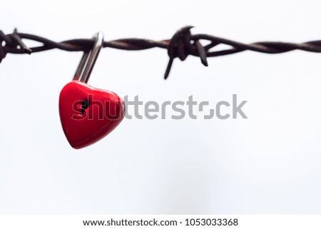 Red heart padlock on metal fence background with copy space