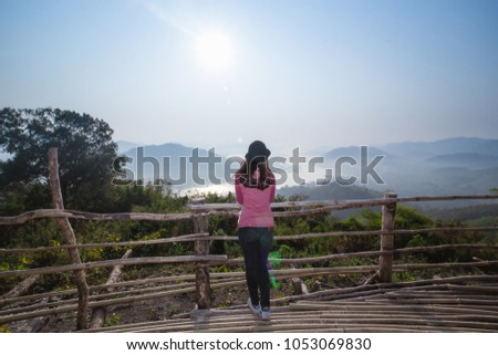 
Soft light of Nature on morning travel woman in red look and camera take picture landscape at Mekong River from the top with Fog over mountain,Nongkhai Thailand,HDR Film  style.