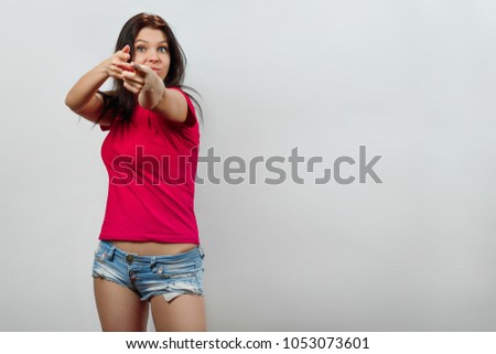 Young, beautiful girl gesture pointing at camera, fingers. Isolated on a light background. Different human emotions, feelings of facial expression, attitude, perception, body language, reaction.
