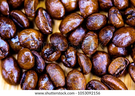 Delicious freshly roasted coffee beans close up isolated against wooden background.