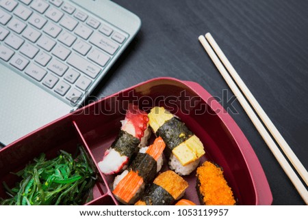 Picture of work lunch box and chopsticks and laptop on the table