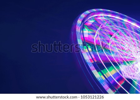 Picture of beautiful ferris wheel with motion blur light at night time