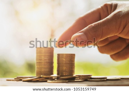 concept saving money with business finance and accounting. hand stack of coins on table