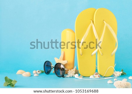 Sunglasses and beach accessories on blue background close up