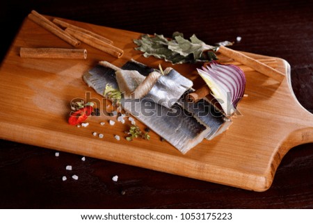herring fillet, on a cutting Board on an old rustic table