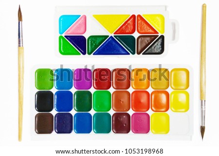 Watercolor paints and brushes isolated on white background, top view