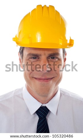 An architect wearing yellow safety helmet looking confidently at camera