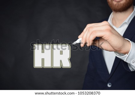 The businessman writes an inscription with a white marker:HR